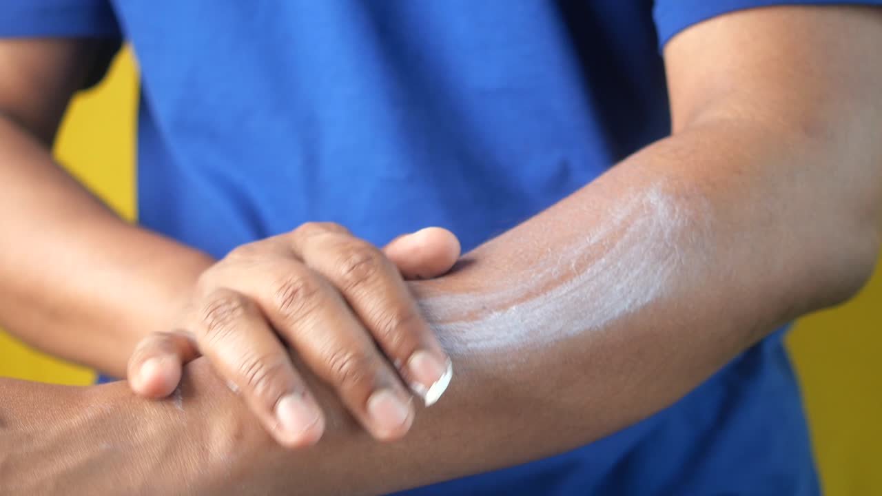 hombre aplicando loción en su brazo