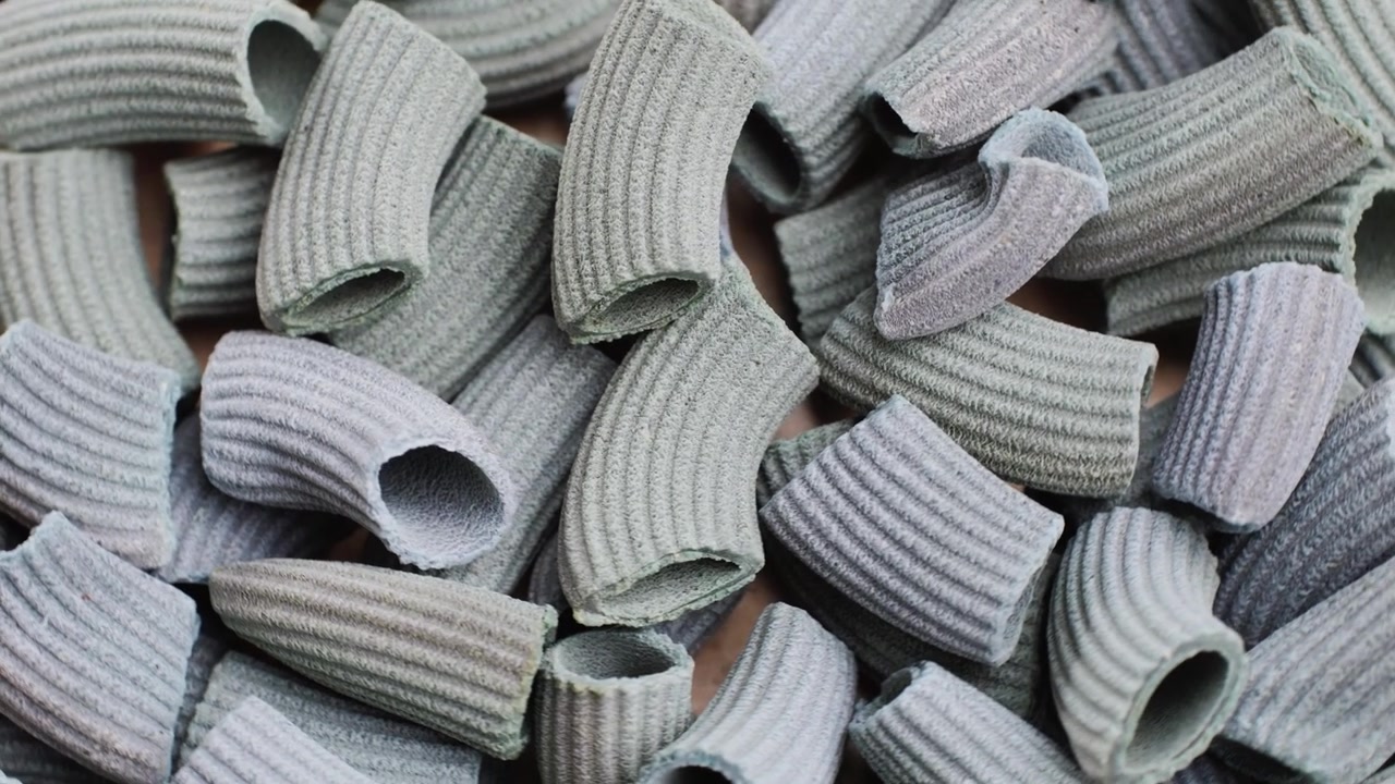Pasta integrale biologica, maccheroni di semola di grano duro, penne rigate crude in una ciotola di legno. Filmato 4k di alta qualità