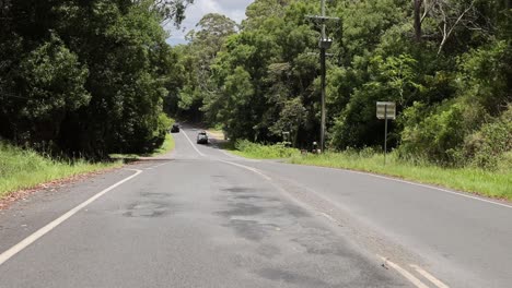 vehicle driving down a winding forest road