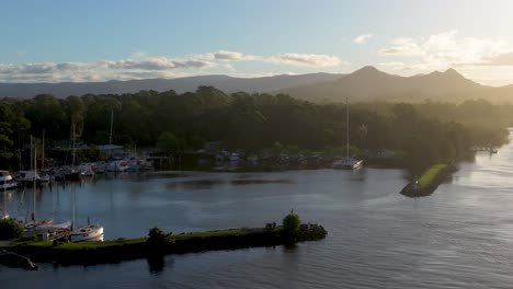 aerial footage captures brunswick heads, australia, with tranquil waters and lush greenery under warm sunset lighting