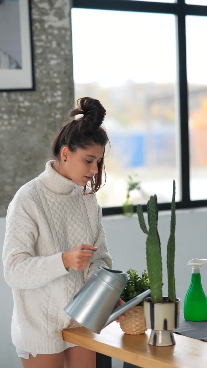 mujer regando plantas de interior