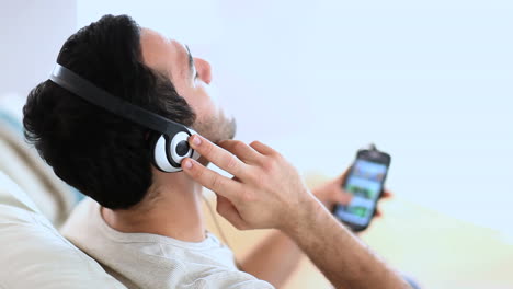 hombre alegre escuchando música con su teléfono inteligente