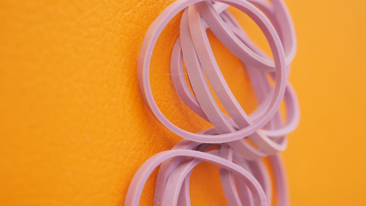 Purple Rubber Bands on Orange Background
