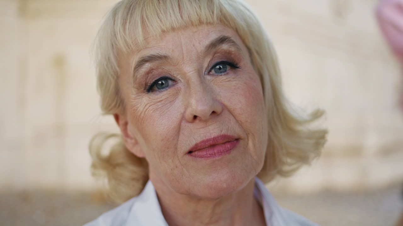 Closeup mature woman face with wrinkled skin and stylish makeup outdoors.