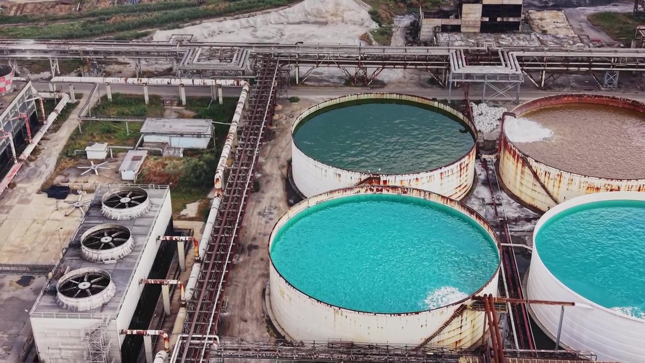 Industrial site with large storage tanks and pipes in a rural area
