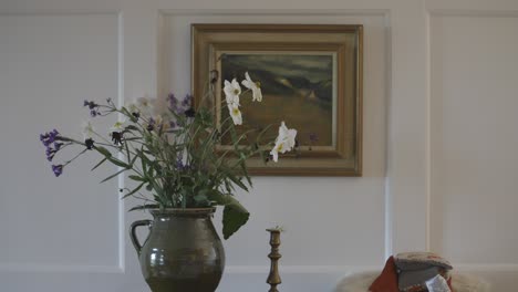 vase of flowers in front of painting