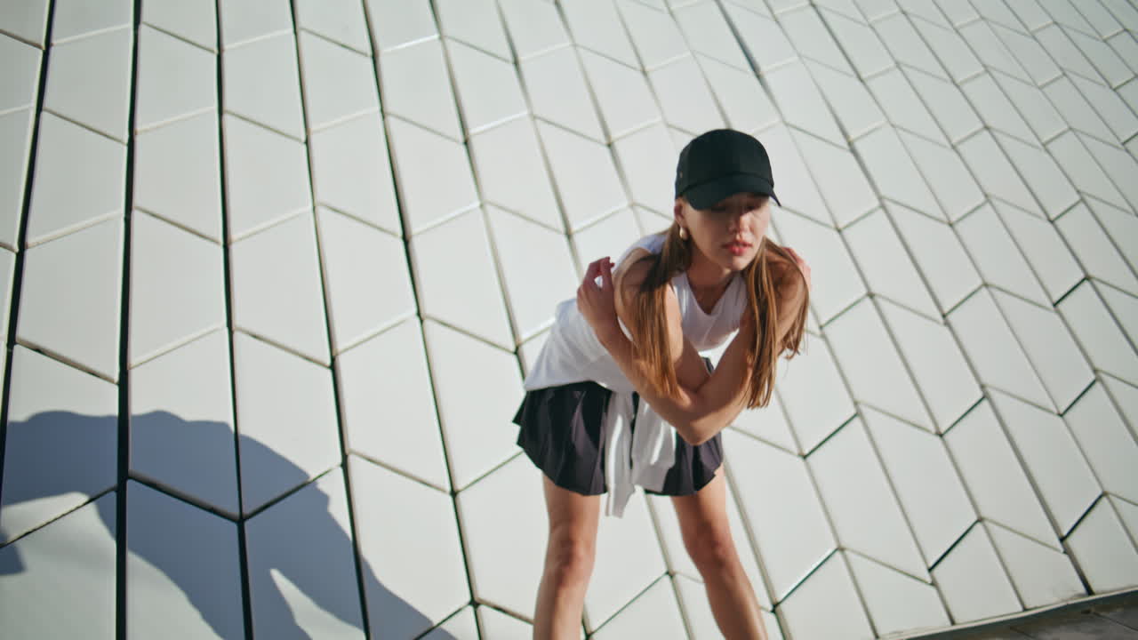 Energetic lady practicing fitness exercises at modern urban architecture closeup