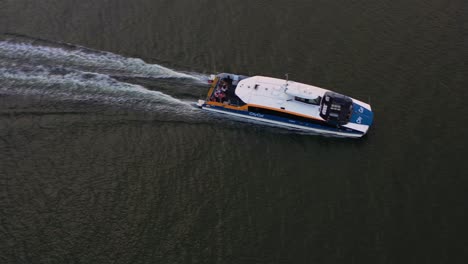 toma de seguimiento de vista aérea de pájaros que captura un ferry citycat catamarán que cruza el río brisbane hacia el suburbio de la costa norte de hamilton al atardecer, queensland, australia