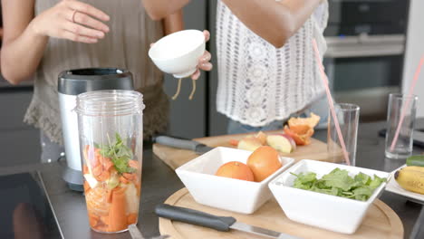 two female friends are preparing a soup with fresh ingredients in a modern kitchen