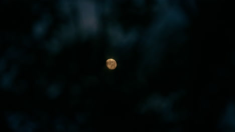 full moon behind the clouds at night