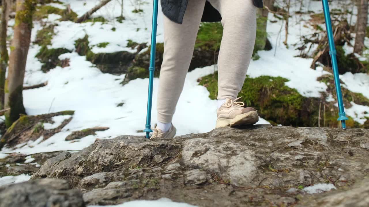 Person Hiking in Snowy Mountains with Hiking Poles