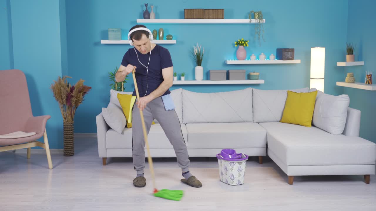 춤을 추면서 집을 청소하는 남자, 좋은 분위기에서.