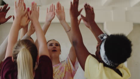 female teacher and students high fiving at dance class