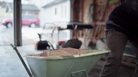 The-Man-is-Loading-Bricks-Into-the-Wheelbarrow-For-Use-in-Constructing-the-DIY-Hot-Tub---Close-Up