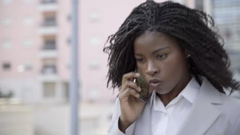 mujer de negocios seria hablando por teléfono inteligente