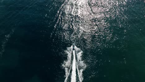 aerial view taken with drone following a jetski on water in slowmotion