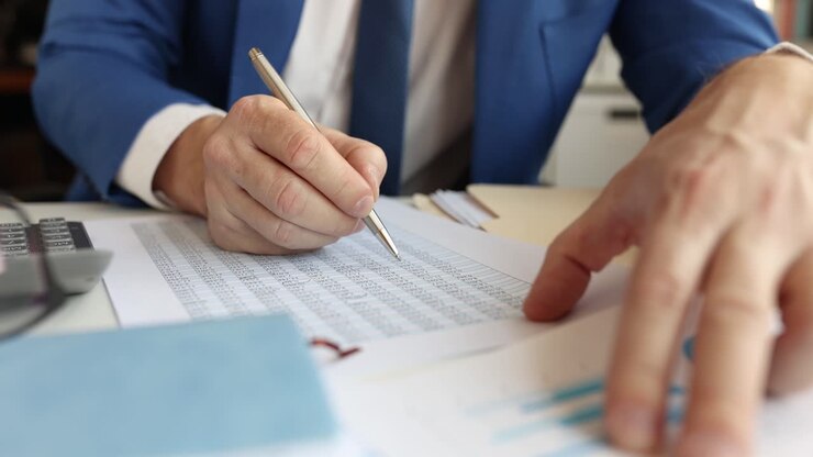 Close up of business man working with finance papers and calculator