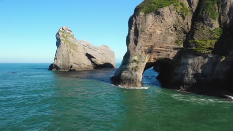 sea waves splashing on rock stacks on a sunny summer day