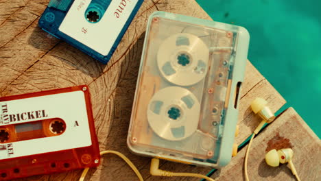vintage cassette tapes on wooden dock by water with headphones