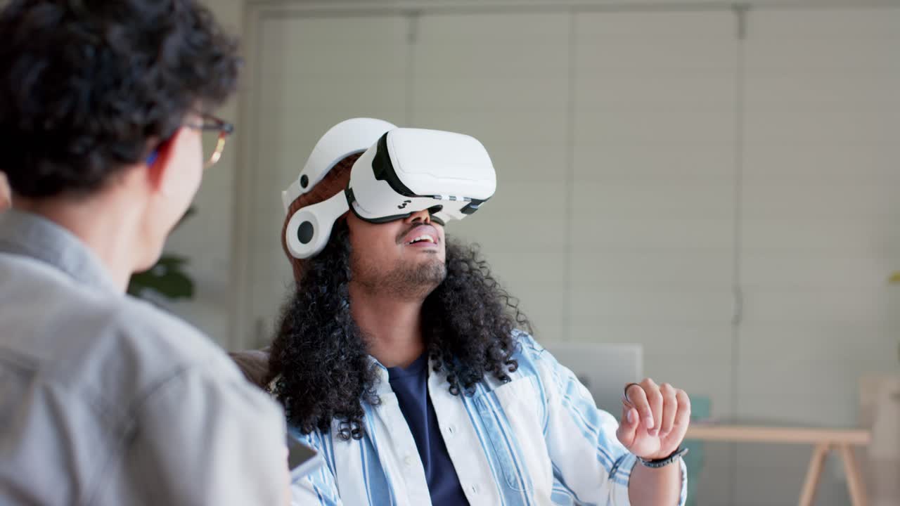 Forskellige kolleger i kontorlounge bruger tablet til at guide VR-headsetbruger, der tester kontrolelementer