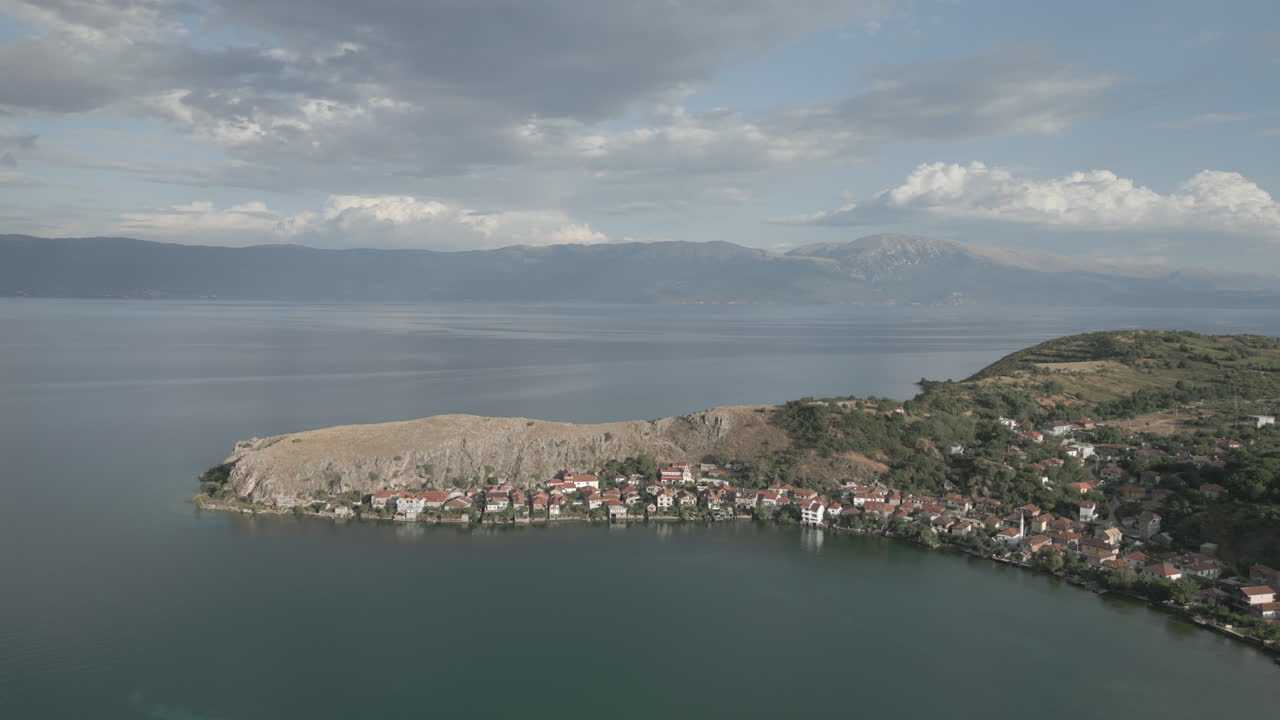 droneshot volando alrededor de la ciudad lin albania en un día nublado cerca del mar con vistas a las montañas de macedonia registro