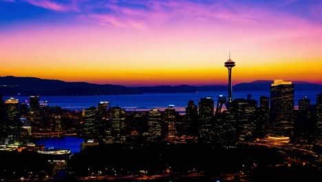 the seattle skyline, featuring the iconic space needle, undergoes a captivating transformation as the sun sets