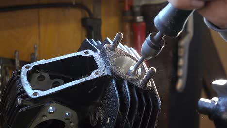 honing tool shapes inside of an engine block in a dark workshop