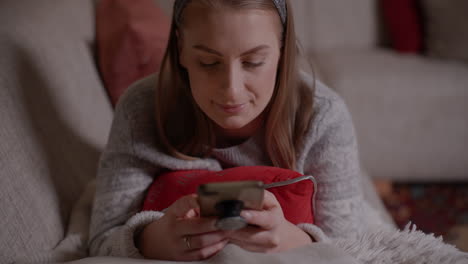 young woman browsing social media on smartphone at home