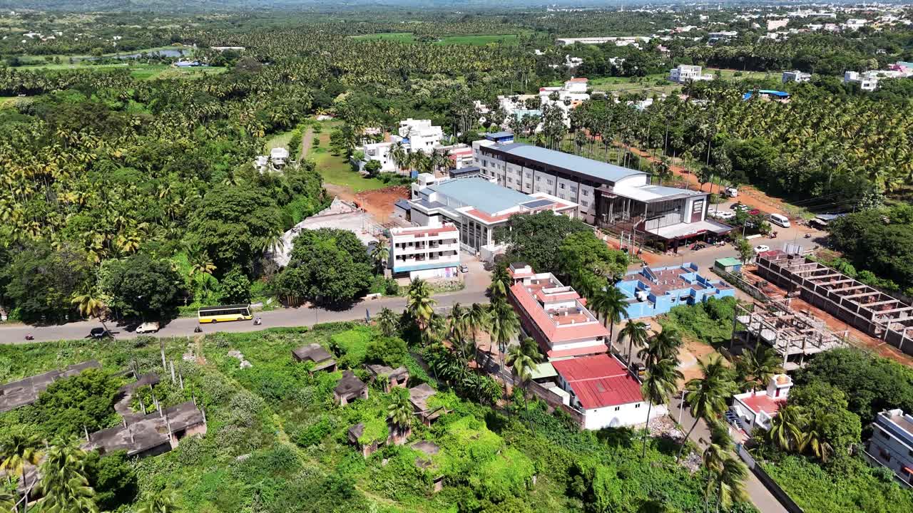A breathtaking aerial footage shows a colourful town nestled at majestic foothills. The dense settlement, surrounded by lush coconut trees