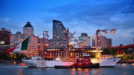 a large old-fashioned ship with wrecked masts and sails. waterfront of new york at dusk time at backdrop
