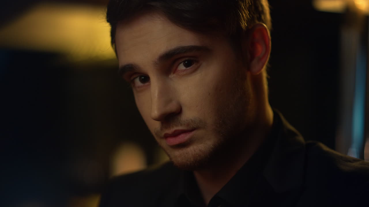 Focused man looking camera indoors. Handsome guy studying someone in front him