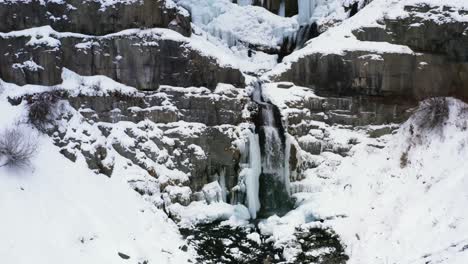 dolly out aerial drone view of the stunning frozen stewart falls waterfall near sundance ski resort in provo that requires a small hike