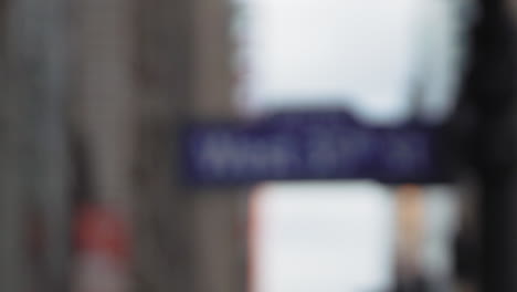 rack focus shot of blue west 35th st. street sign in daytime new york city.