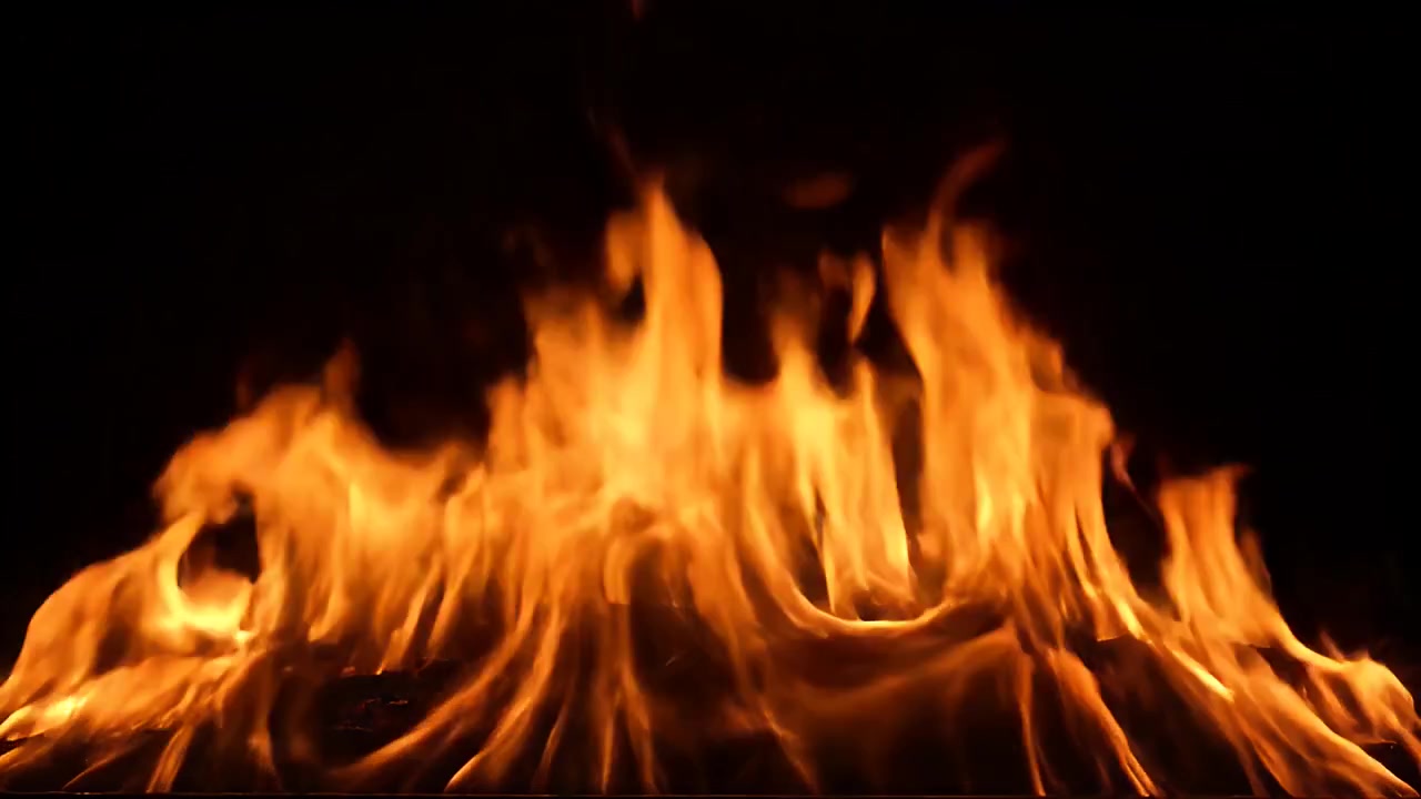Klare orange flammer brændende mod en solid sort baggrund