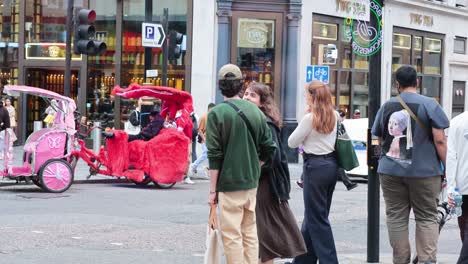 people walking past colorful rickshaws in london