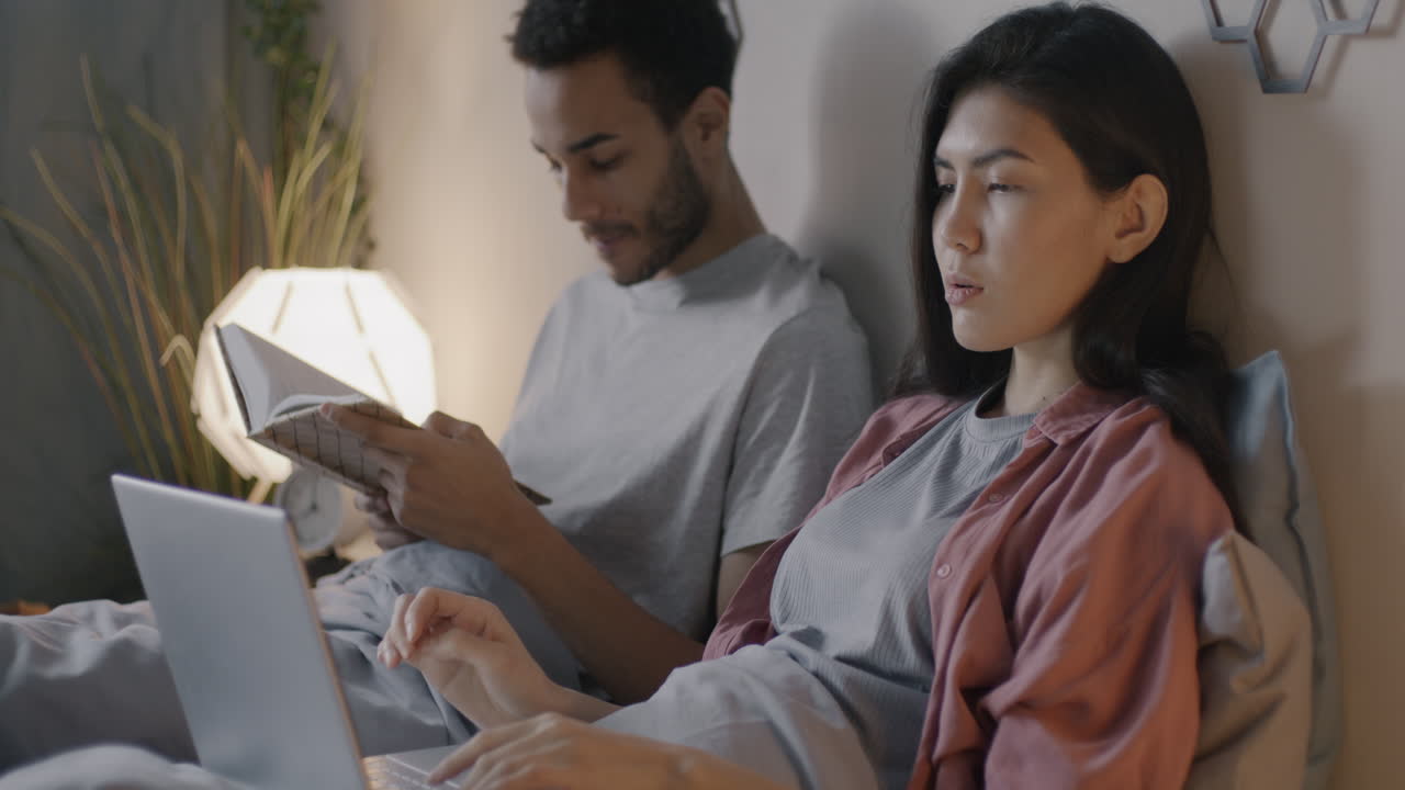 Couple relaxing in bed at night
