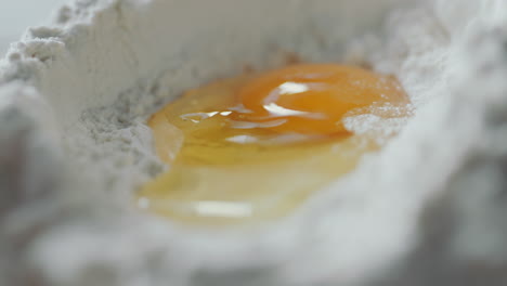 pouring egg in flour mound