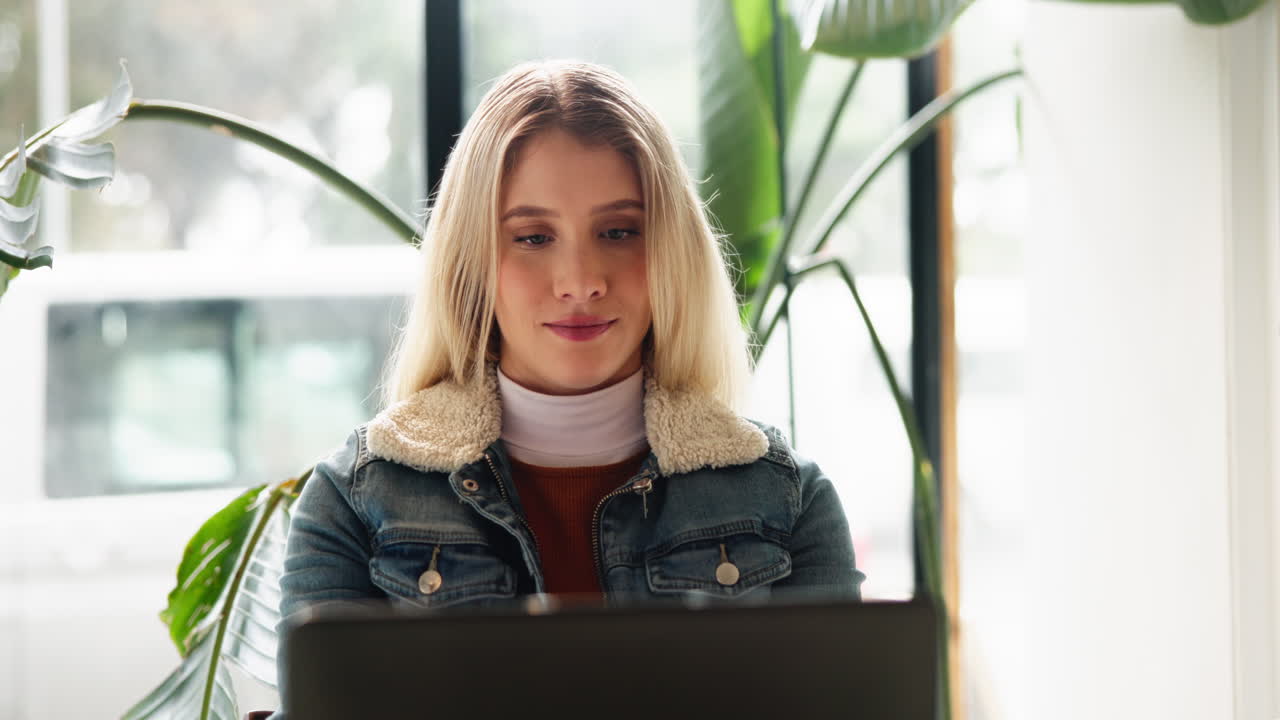 mujer trabajando en una computadora portátil en un café