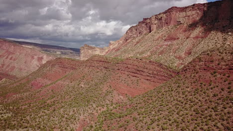 aerial of dirt road with butte mesa flat top mountain on a beautiful day in desert southwest colorado usa