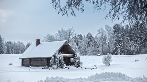 Time-lapse-shot-of-wooden-house-in-nature-covered-in-snow-after-snowstorm-at-night---Sunrise-behind-cloudscape-at-sky---Person-snow-shoveling-path