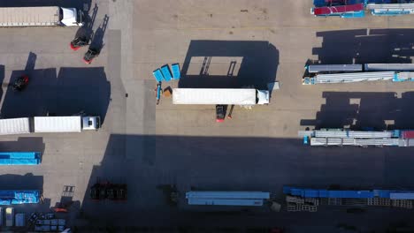 los camiones con semirremolques se paran en el estacionamiento del parque logístico con centro de carga y esperan la carga y descarga de mercancías en las rampas del almacén al atardecer