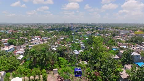 aerial flyover cable car over green city of los alcarrizos near santo domingo during sunny day