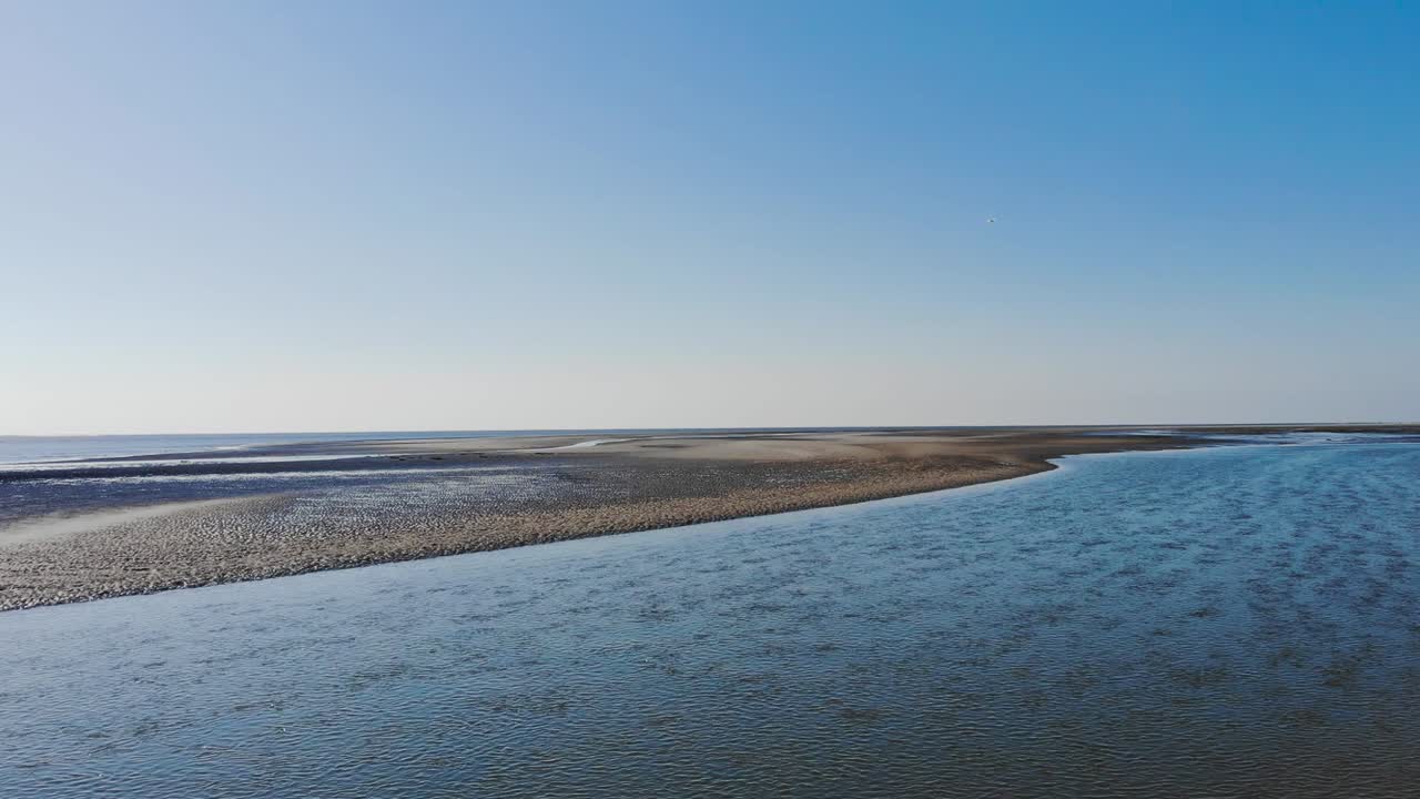 Aerial, drone shot over a river on a beach, sunny day, on Langeoog island, at the Nordsee, in North Germany