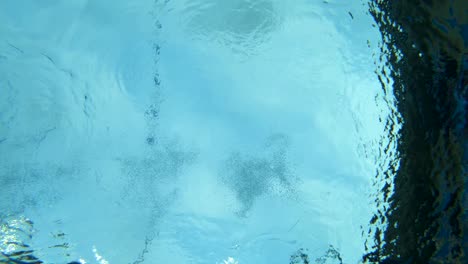 Underwater-shot-of-a-woman-diving-full-speed-into-a-swimming-pool