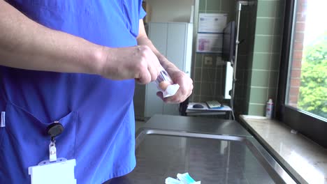 medical personnel put a drug in a syringe to administer it to a patient