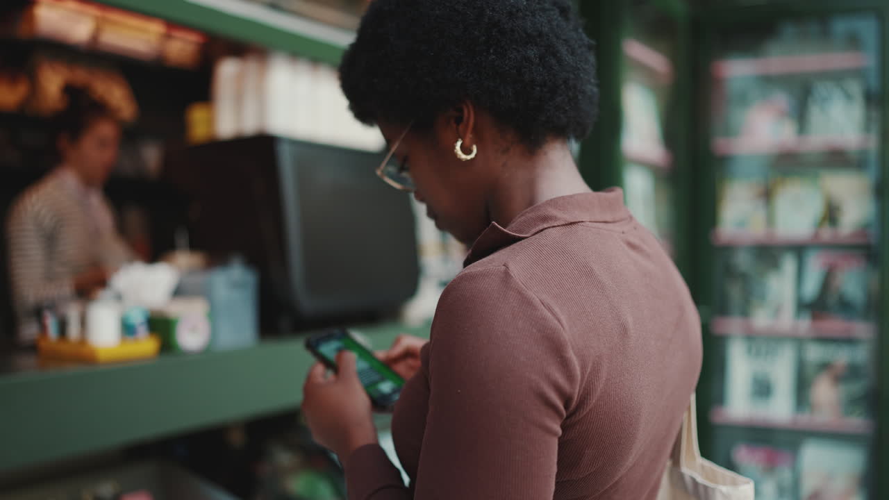Dark-skinned girl is standing outdoors with smartphone
