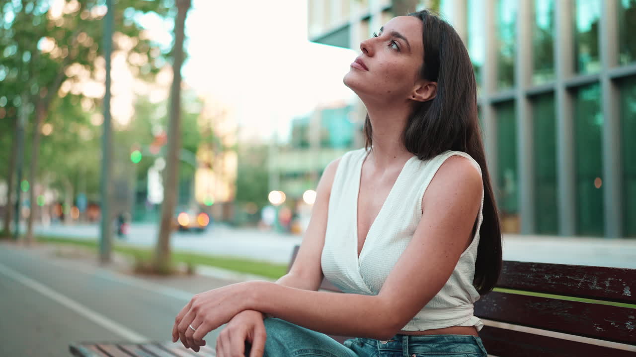 Woman sitting on a bench in a city