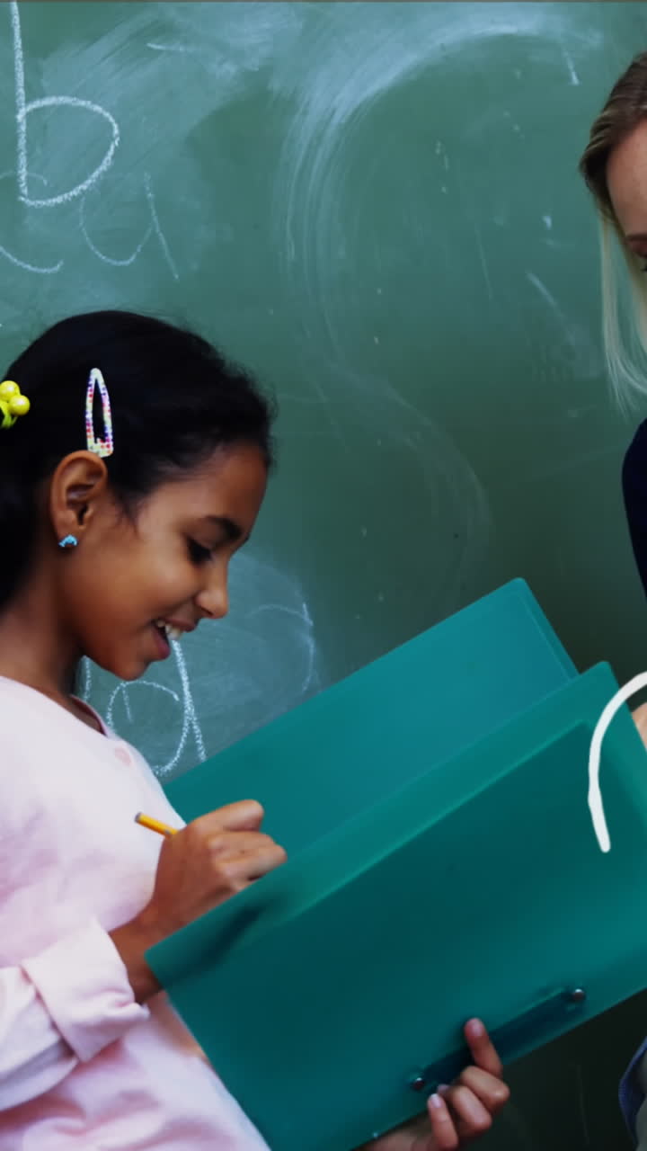 video compuesto de iconos del concepto escolar contra una maestra caucásica que enseña a una niña en clase