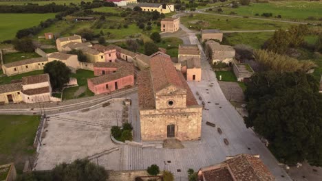 establisher aerial view of tratalias church and square, sardinia, lowering, day