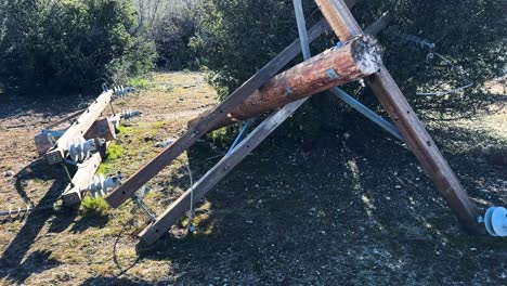 electrical-distribution-pole-buck-arm-top-cross-arm-laying-on-the-ground-after-being-cut-down-with-polymer-and-Hendrix-insulators-attached-during-sunset